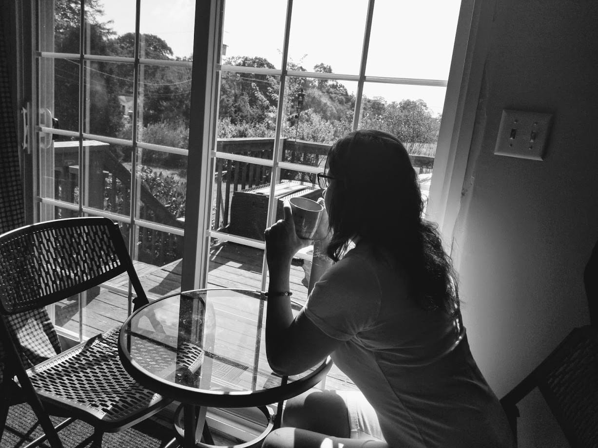 a woman sitting at a table looking out the window