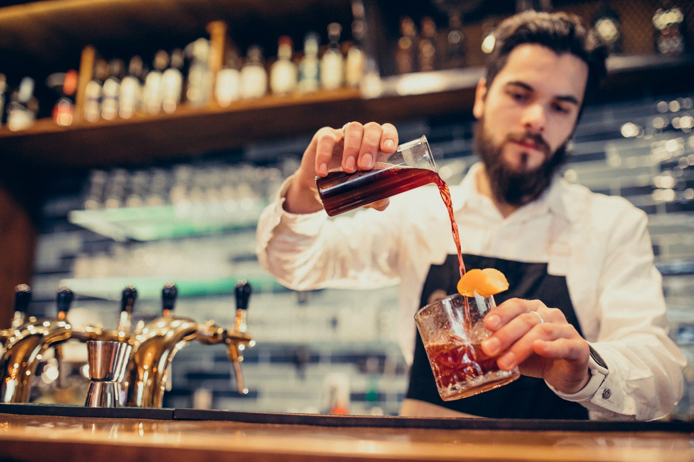 A person pouring liquid into a glass Description automatically generated with low confidence