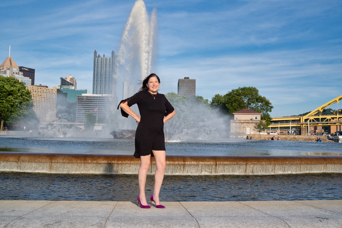 A person standing in front of a fountain Description automatically generated