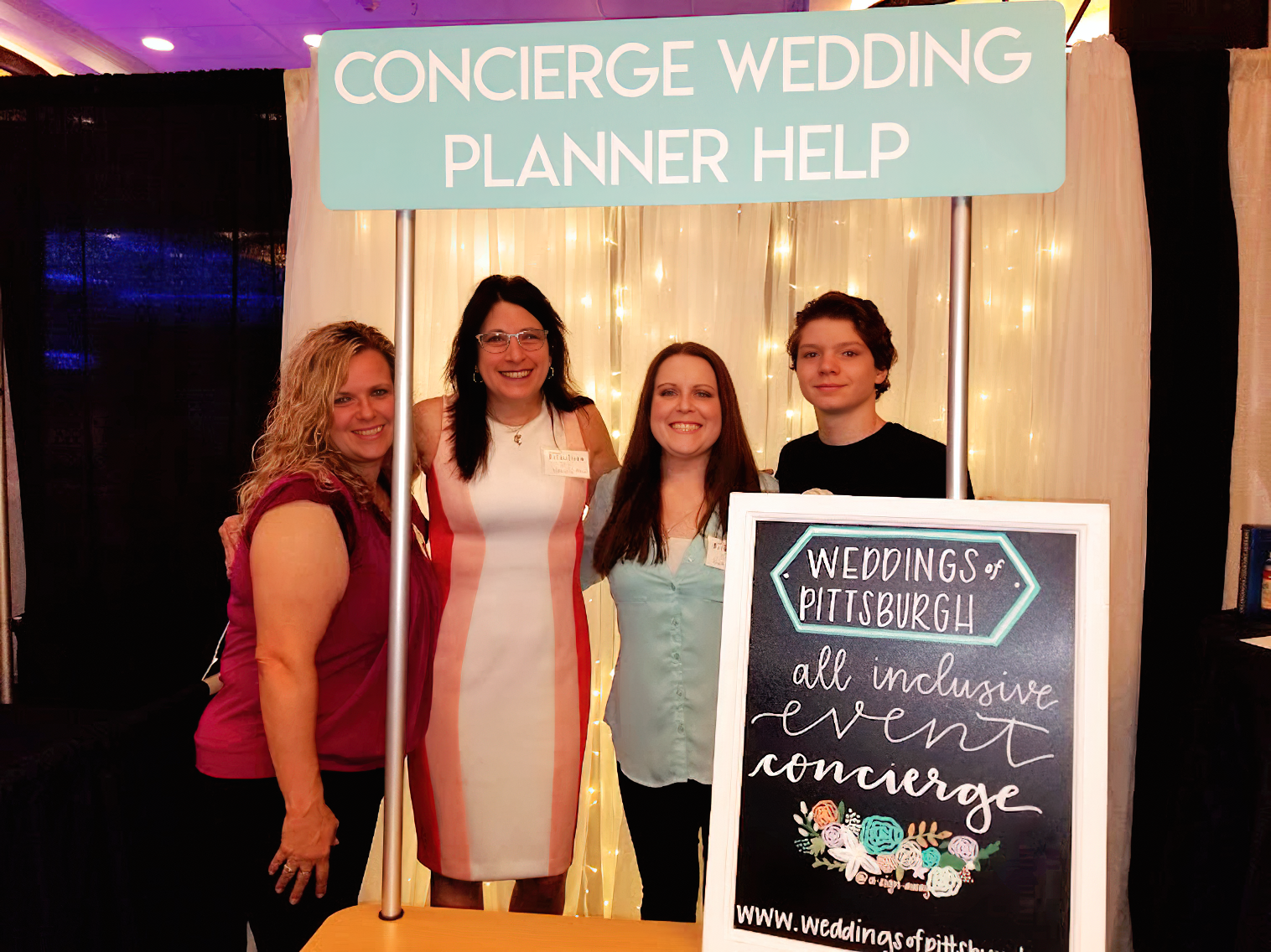a group of women standing in front of a sign