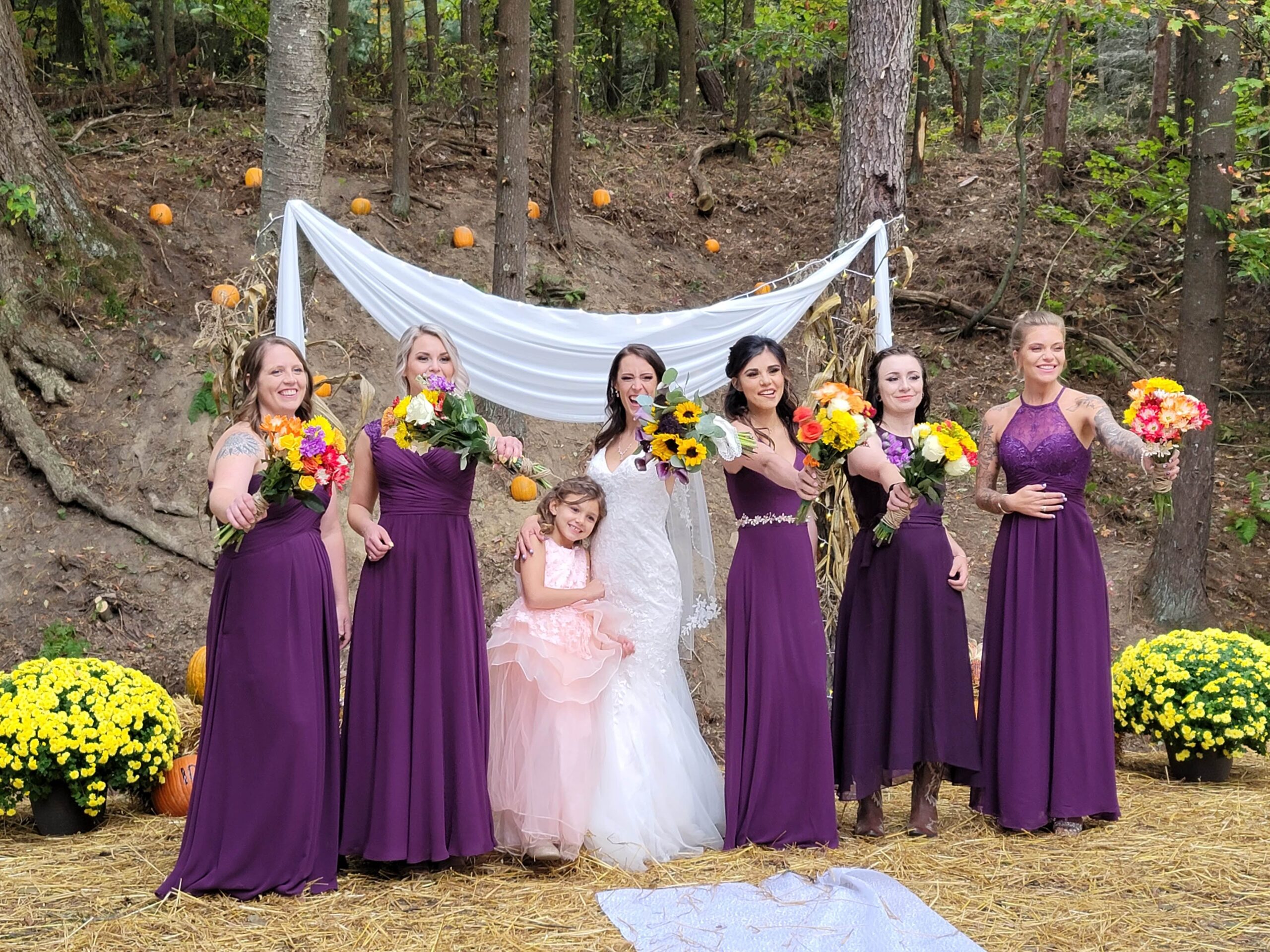 a group of women in purple dresses standing next to each other