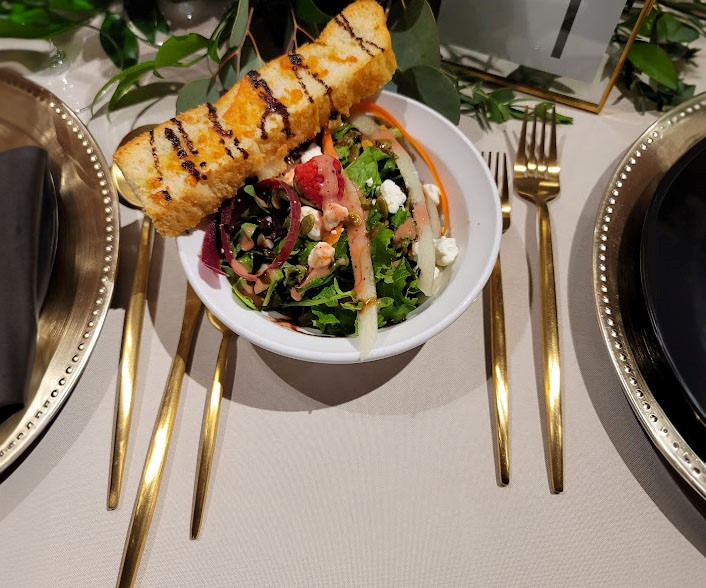 a salad and chicken skewers on a table