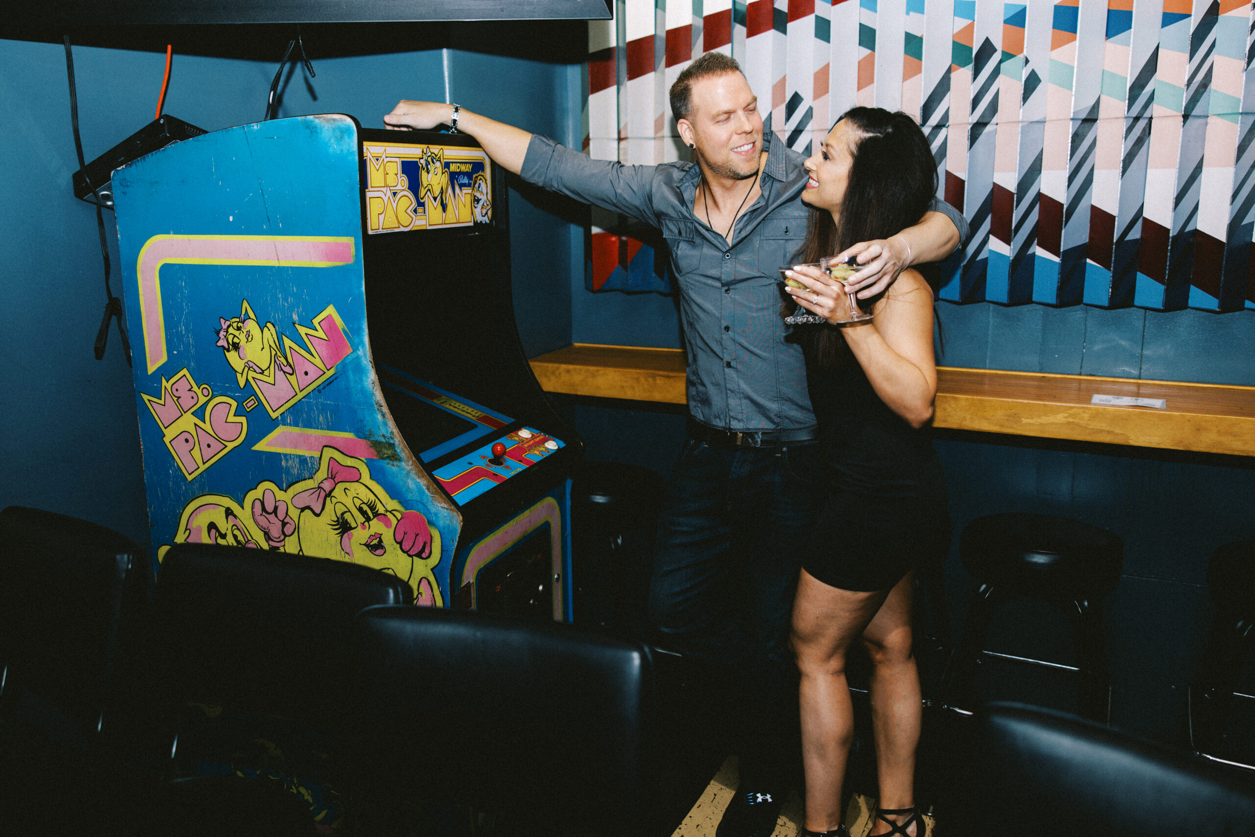 Alyssa & Steve standing next to each other in front of a pinball machine