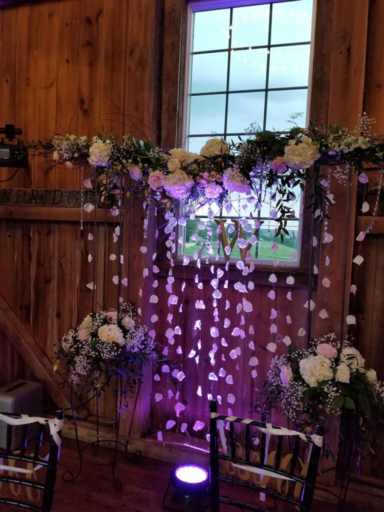 a purple and white wedding setup in a barn
