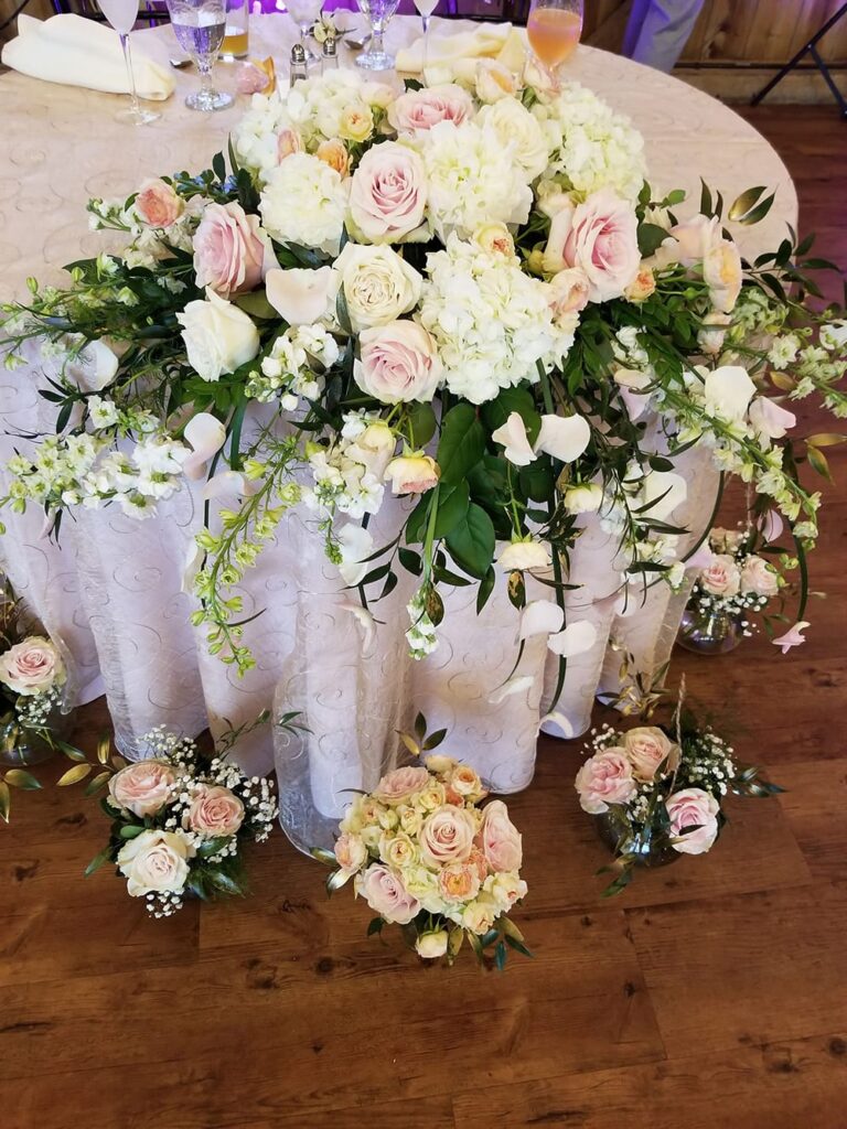a table topped with lots of white and pink flowers