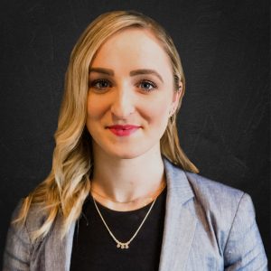 a woman with blonde hair wearing a gray jacket