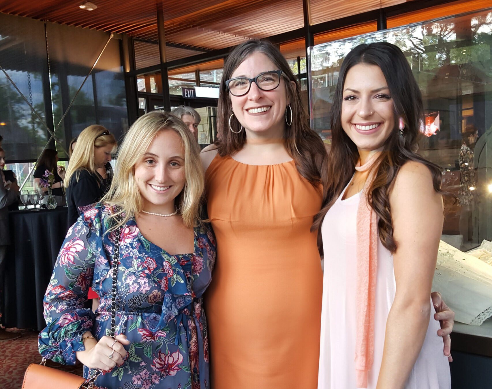 three women standing next to each other smiling